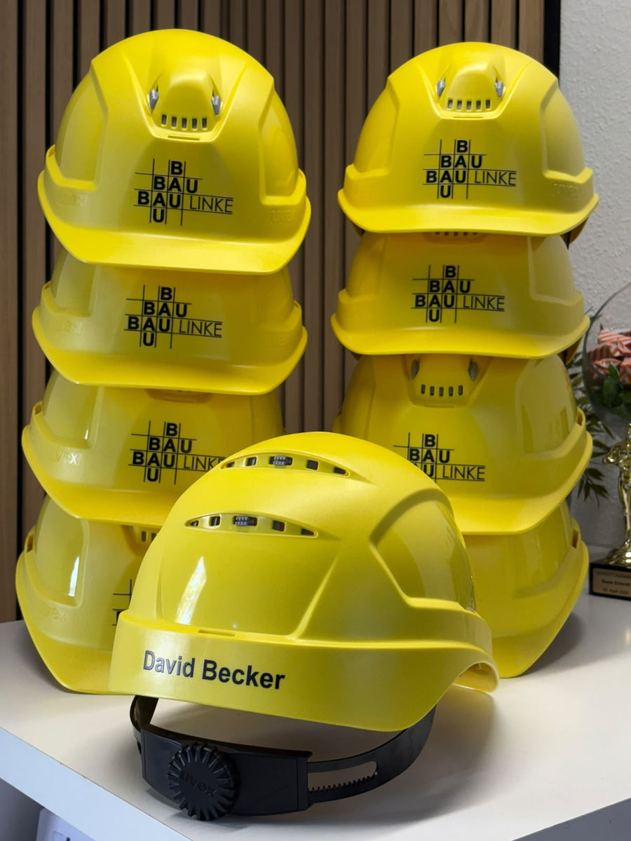 Gelbe Bauhelme mit Logo der Bau Linke GmbH – von LASERPIX veredelt
